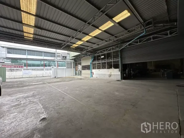 Warehouse for rent in Yan Nawa, Bangkok - Covered loading bay of the Yan Nawa warehouse with high metal roof, roller shutters and a wide driveway.