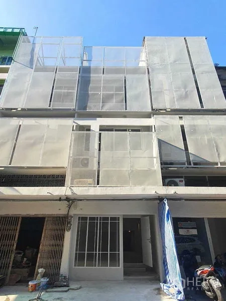 Shophouse for rent in Phra Khanong, Bangkok - Modern multi-storey shophouse exterior with perforated metal facade and ground-level entry.