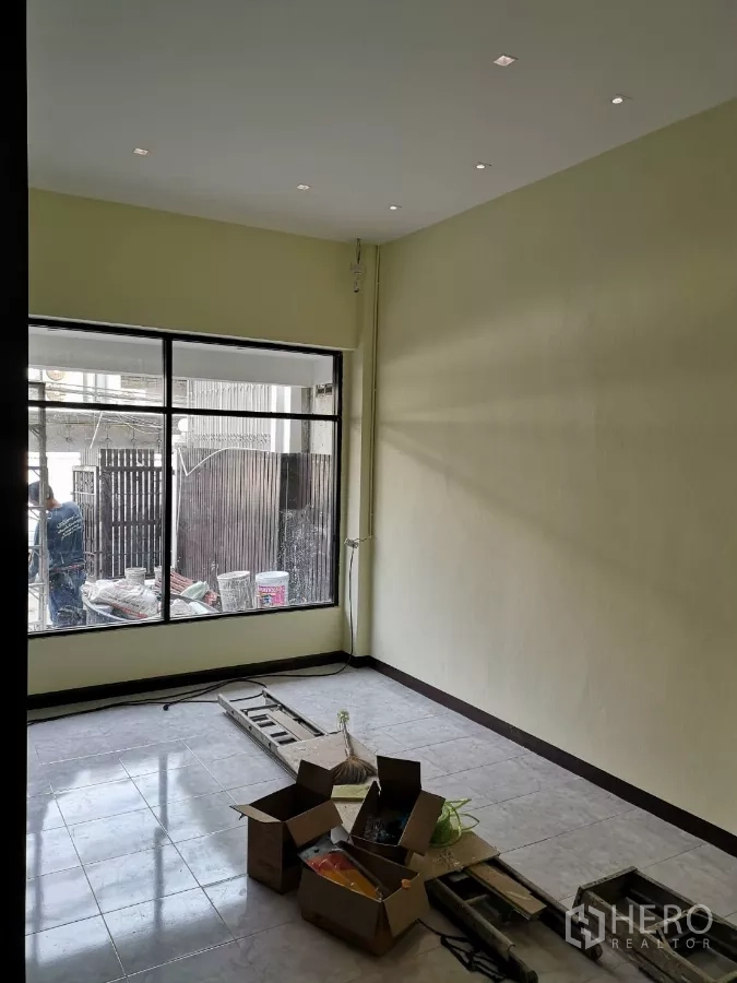 Home Office for rent in Yan Nawa, Bangkok - Corner room with large window, recessed lights and tiled flooring, renovation tools on the floor.