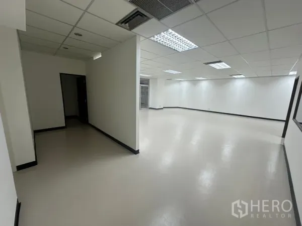 Office Space for rent - Wide corridor leading to an open work area with partial wall divider and ceiling air vents.
