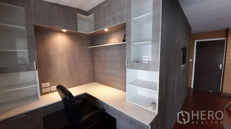 Townhouse for rent or sale in Suan Luang, Bangkok - Built-in home office corner with desk, cupboards, and shelving.