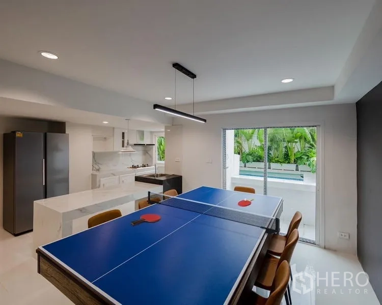 Townhouse for sale - Dining area converted to a ping-pong table beside sliding doors to the pool terrace.