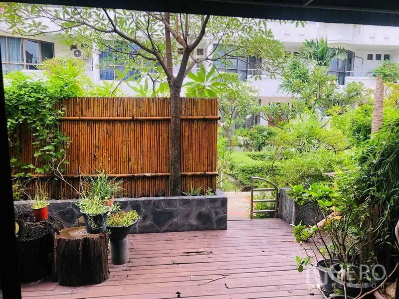 Townhouse for rent in Yan Nawa, Bangkok - Private wooden deck with bamboo privacy screen overlooking a green courtyard garden.