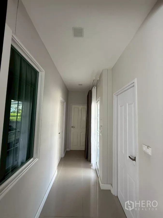 Detached House for rent in Bang Phli, Samut Prakan - Bright hallway with glossy tiles and multiple white doors.