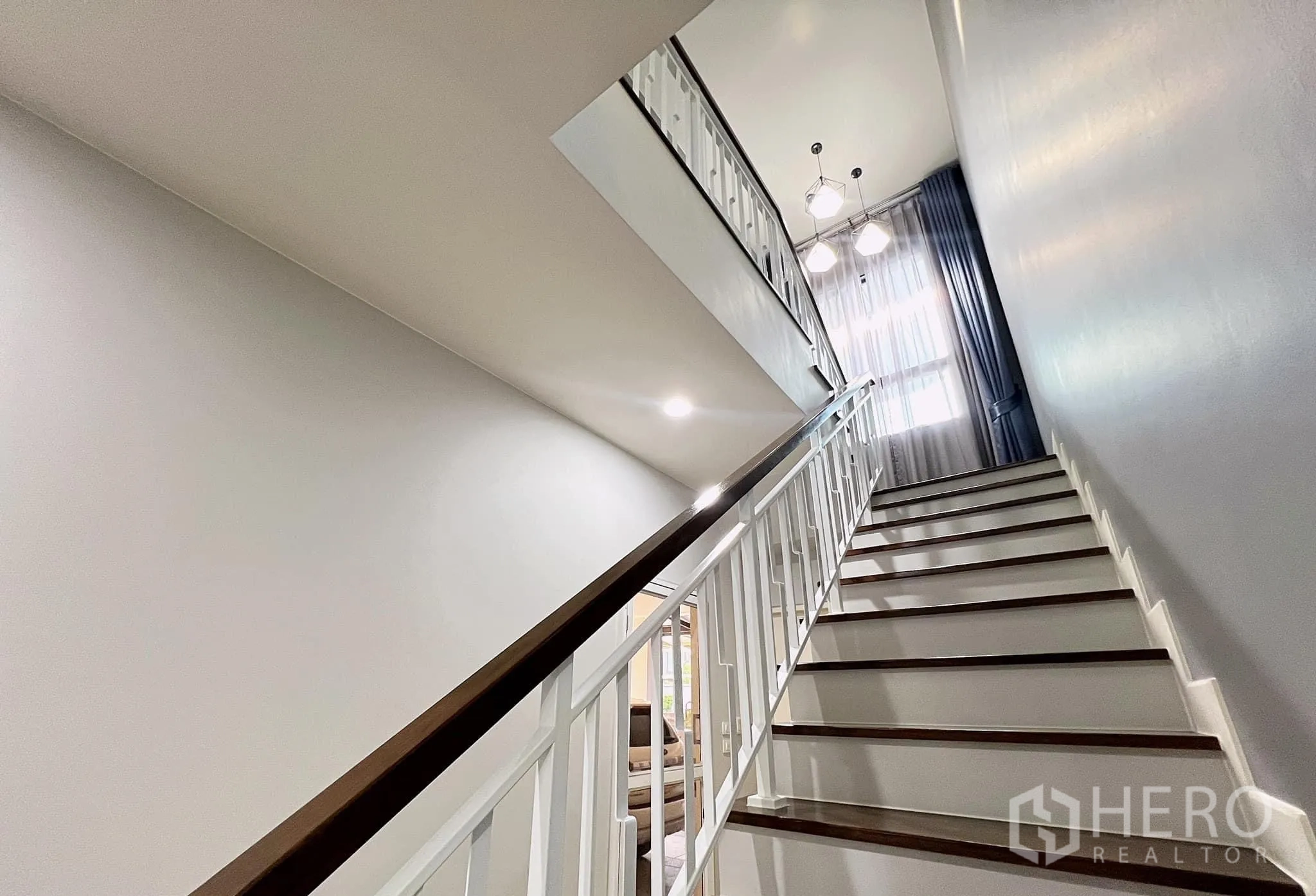 Detached House for rent or sale in Lam Luk Ka, Pathum Thani - Staircase with white balustrade and tall window bringing natural light.