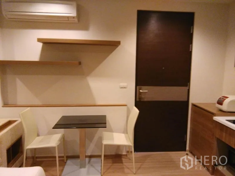 Condominium for rent in Sathon, Bangkok - Compact dining nook by the entrance door with floating shelves.