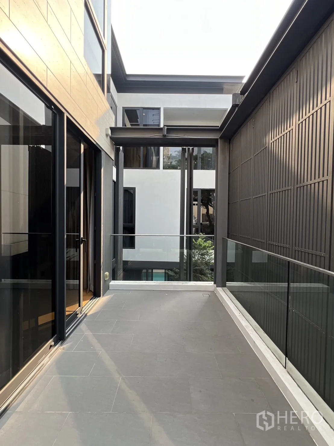 Detached House for rent in Suan Luang, Bangkok - Side terrace corridor with glass balustrade between buildings.