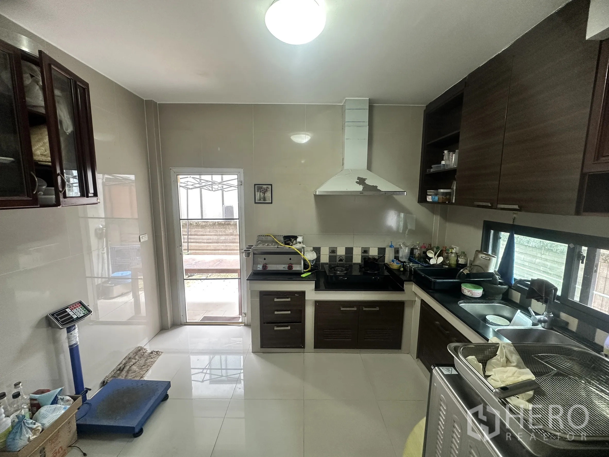 独栋房屋 for sale in Pak Kret, Nonthaburi - 封闭式厨房，灶台、抽油烟机、橱柜与侧门。
