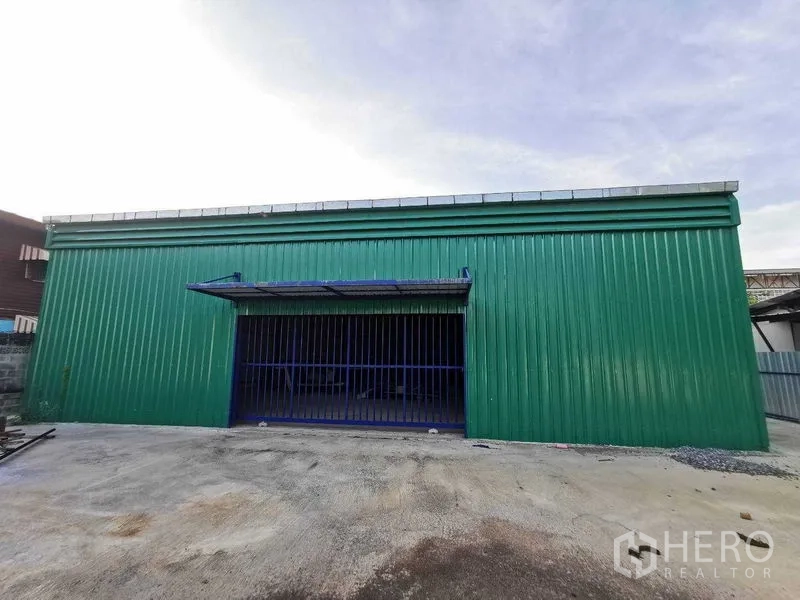 Warehouse for rent in Bang Na, Bangkok - Front of green metal-clad warehouse with large blue sliding door