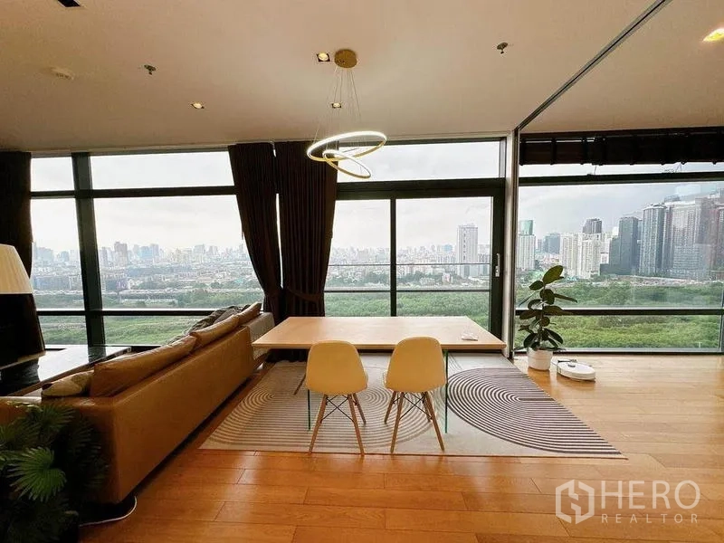 คอนโด ให้เช่าในRatchathewi, Bangkok - พื้นที่นั่งเล่นและรับประทานอาหารแบบโอเพ่น พร้อมหน้าต่างพาโนรามา โคมไฟวงแหวน และวิวเมืองกับพื้นที่สีเขียว