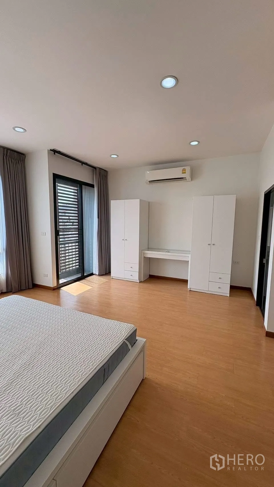ทาวน์เฮาส์ for rent in Phra Khanong, Bangkok - ห้องนอนใหญ่พร้อมประตูกึ่งระเบียง ตู้เสื้อผ้าสองใบ โต๊ะทำงาน และแอร์
