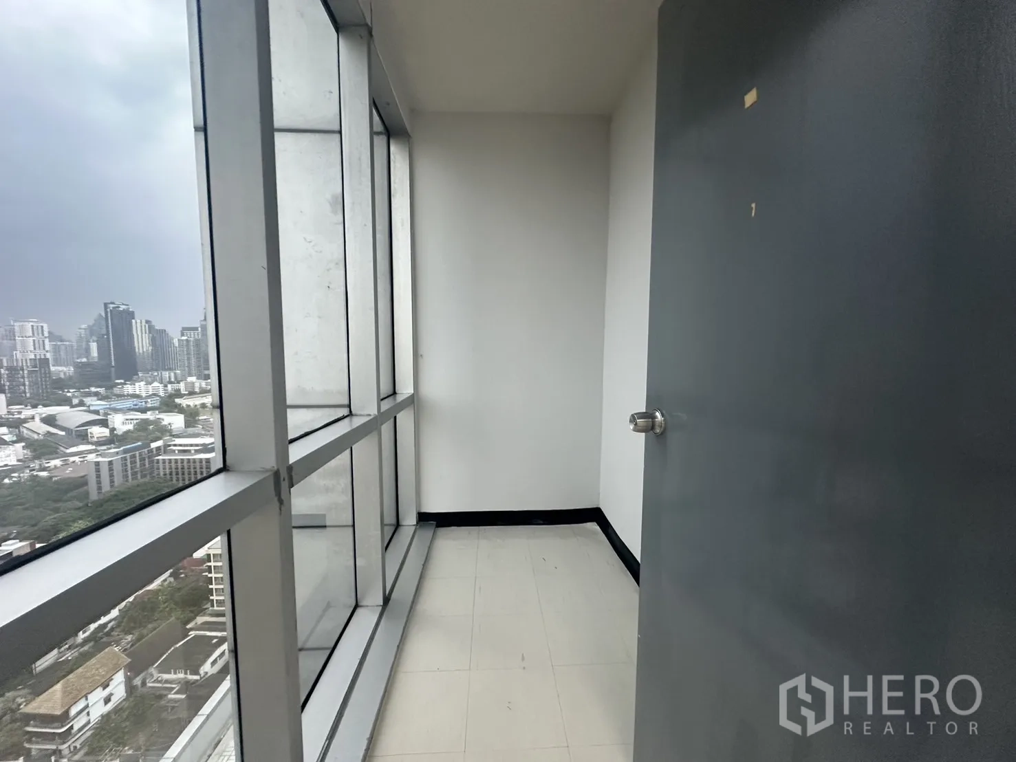 Office Space for rent - Compact internal area with floor-to-ceiling glazing and a door, showing city views.