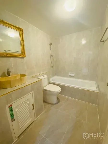 Condominium for rent or sale in Watthana, Bangkok - Bright bathroom with bathtub, handheld shower and gold-framed mirror.