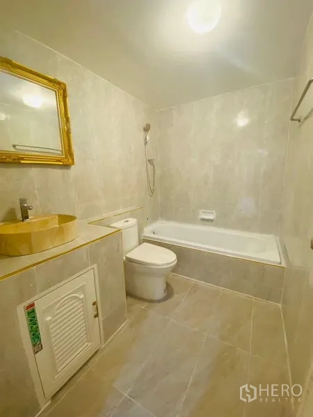 Condominium for rent or sale in Watthana, Bangkok - Bright bathroom with bathtub, handheld shower and gold-framed mirror.