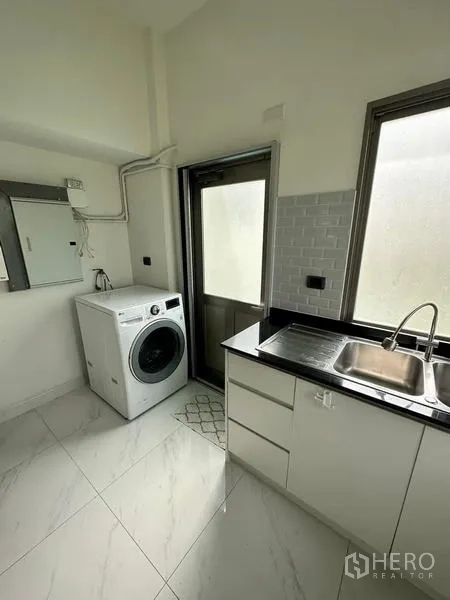 Detached House for rent in Bang Phli, Samut Prakan - Laundry room with a front-load washing machine, sink, exterior door and frosted windows.