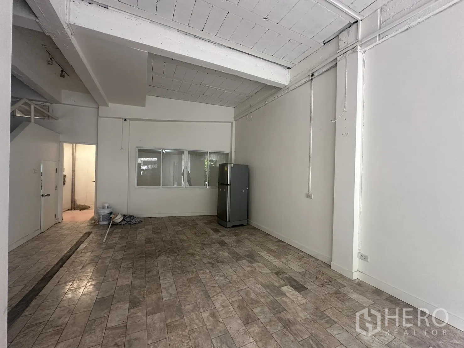 โฮมออฟฟิศ for rent in Watthana, Bangkok - มุมมองโถงชั้นล่างพร้อมผนังกั้นกระจกและตู้เย็น.