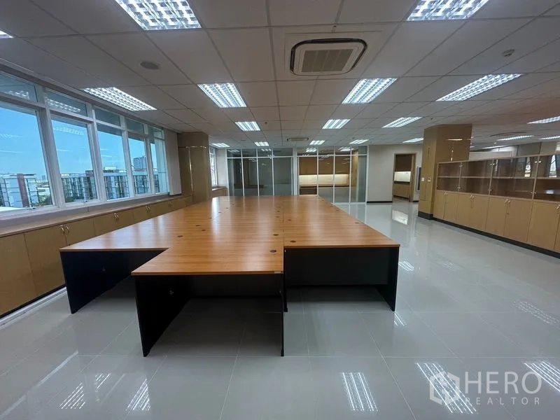 Office Space for rent in Suan Luang, Bangkok - Large office area with U-shaped shared workstations, city-facing windows, and built-in cabinets.