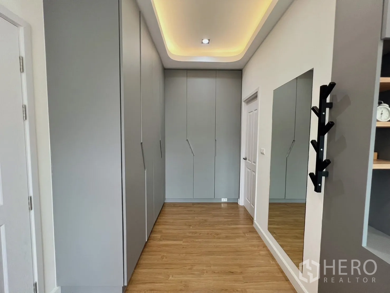 Detached House for rent or sale in Khlong Luang, Pathum Thani - Wardrobe corridor with large mirror and wood flooring.