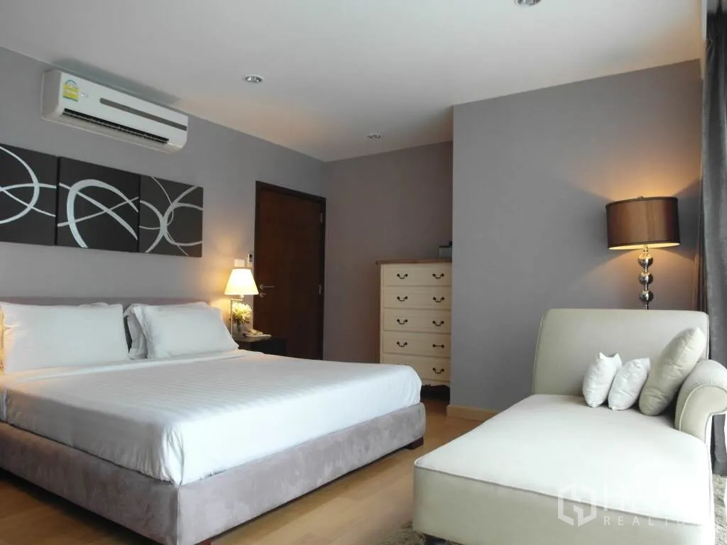 คอนโด ให้เช่าหรือขายในSathon, Bangkok - ห้องนอนหลักกว้าง เตียงคิง โซฟาเชสเลานจ์ แสงไฟอบอุ่น และผนังโทนเทา