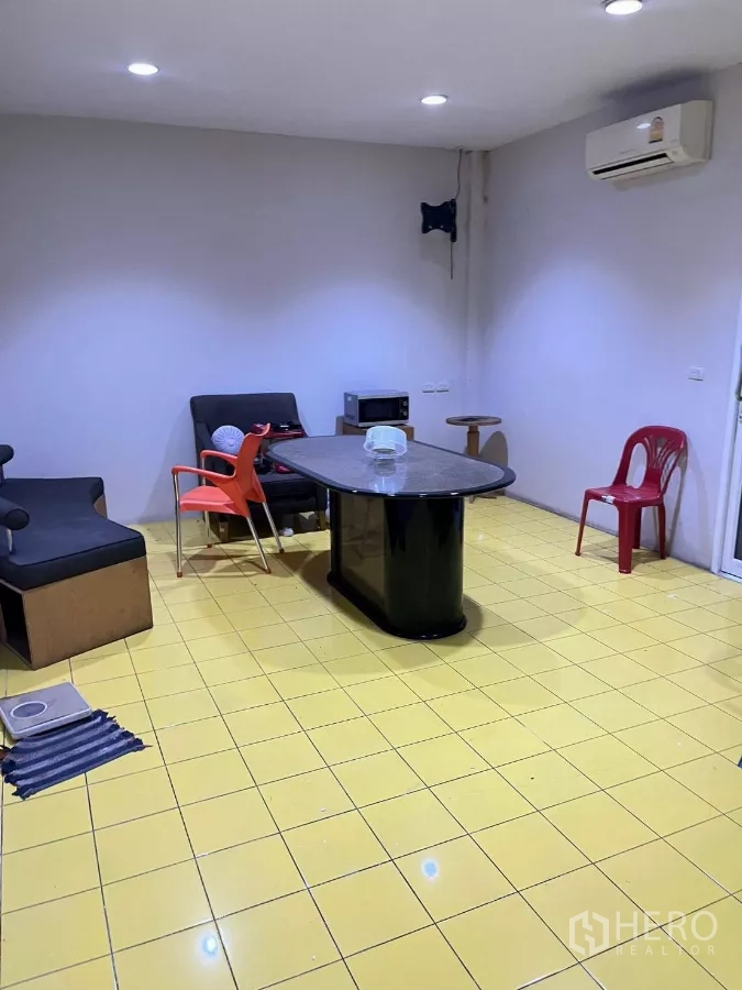 Home Office for rent in Khlong Toei, Bangkok - Multipurpose room with yellow tiled floor, lounge seating and wall-mounted air conditioner.