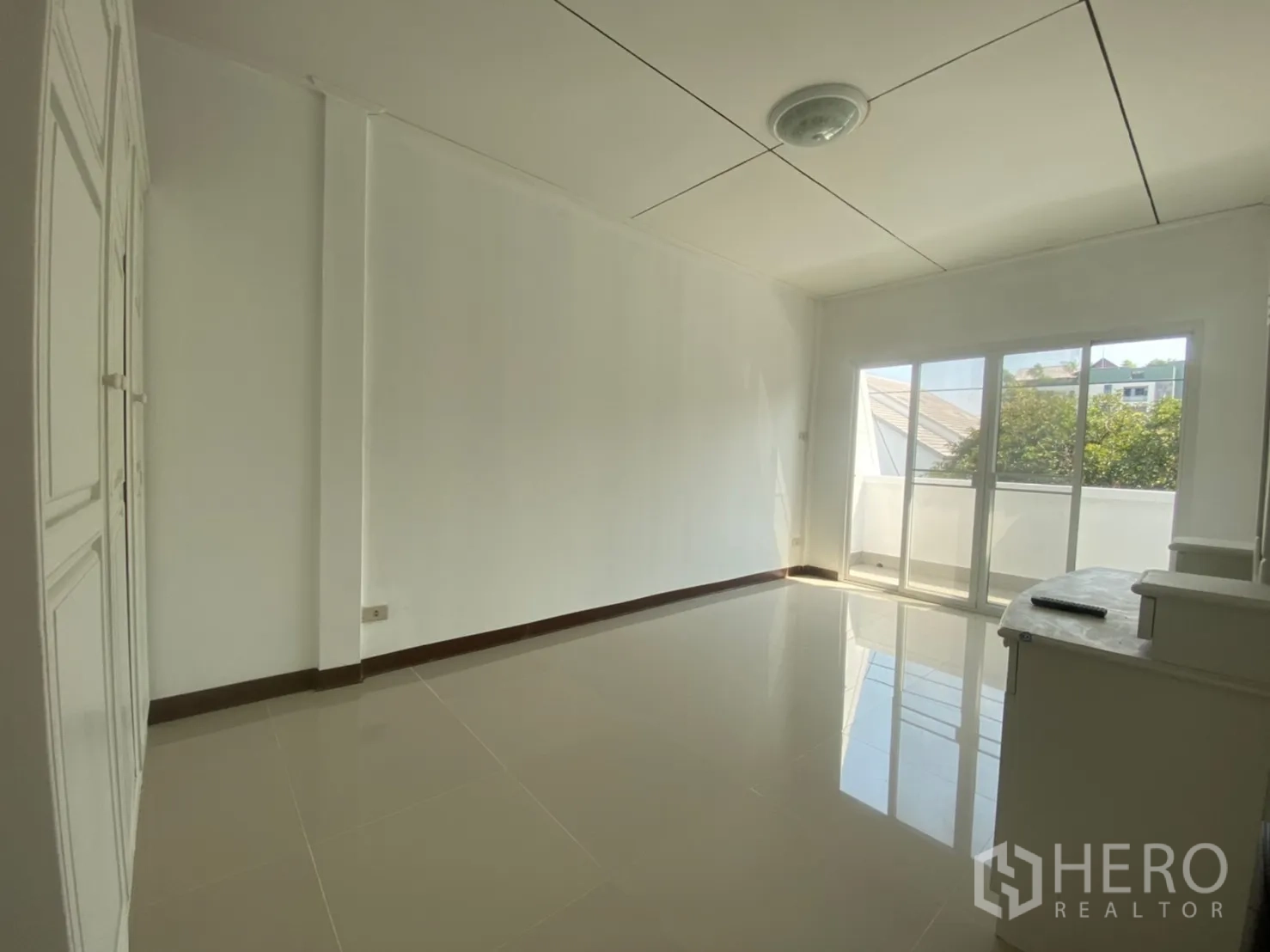 Townhouse for rent in Watthana, Bangkok - Bedroom with sliding doors to a balcony and built-in closet.