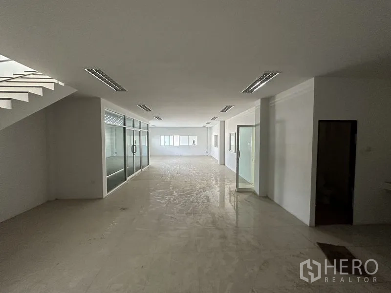 Factory for rent in Bang Bo, Samut Prakan - Wide-span warehouse interior with louvered vents, arched roof and concrete floor.