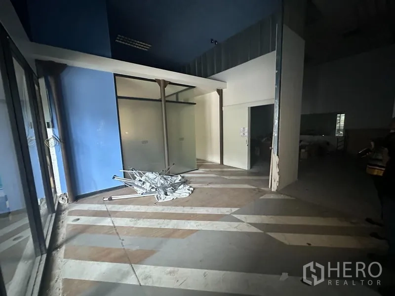 Office Space for rent in Khlong Toei, Bangkok - Reception-style area with blue feature wall, frosted glass partitions and striped floor, shown in unfinished condition.