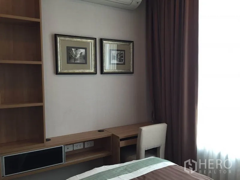 公寓 出租在Ratchathewi, Bangkok - 卧室角落带嵌入式书桌与置物架，墙上双幅装饰画，临窗而设。