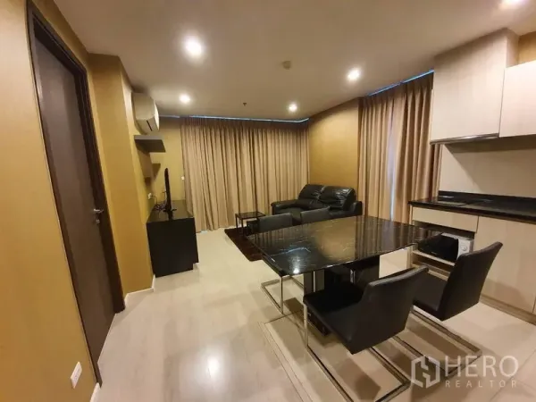 公寓 出租在Sathon, Bangkok - 起居区设大理石餐桌与四椅，旁边为沙发与落地窗帘。