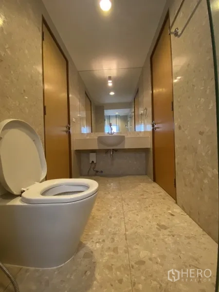 房间 出租在Watthana, Bangkok - 狭长浴室，配洗手台与马桶，浅色石材装饰。