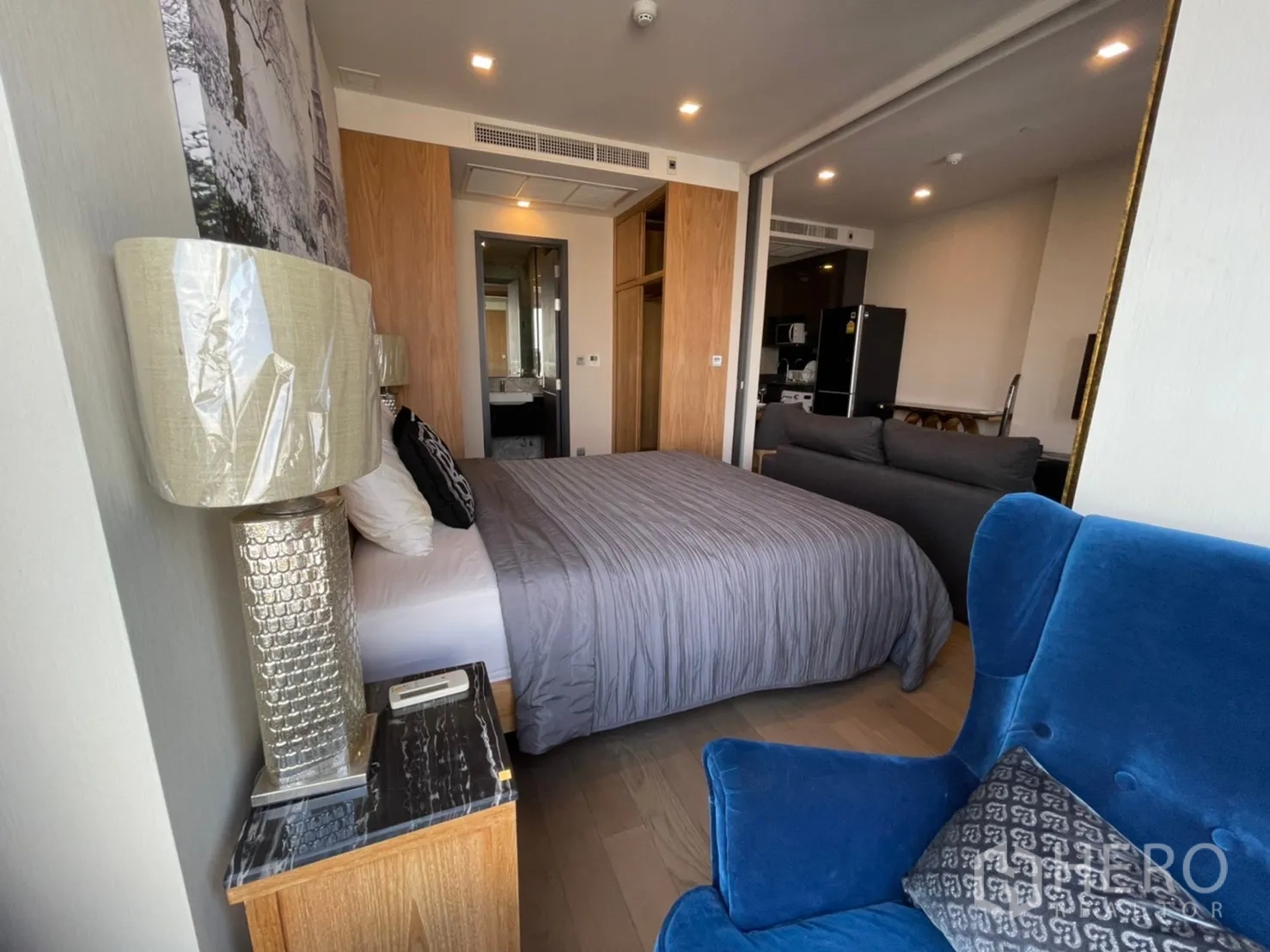 คอนโด for rent in Watthana, Bangkok - มุมห้องนอนมีเก้าอี้นั่งเล่น โคมไฟข้างเตียง และหน้าต่างรับวิวเมือง