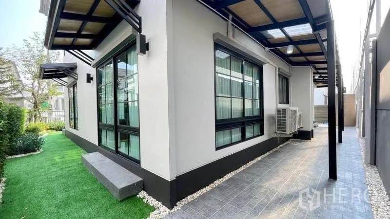 独栋房屋 for rent or sale in Bang Phli, Samut Prakan - 侧院人造草坪，大窗与连廊雨棚