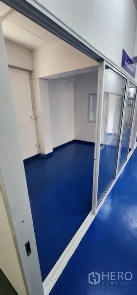 Warehouse for rent in Bueng Kum, Bangkok - Compact production or office room with sliding glass door and blue epoxy floor.