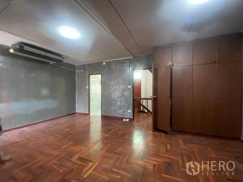 联排别墅 出租在Watthana, Bangkok - 大房间，灰色质感特色墙与嵌入式衣柜，木地板。