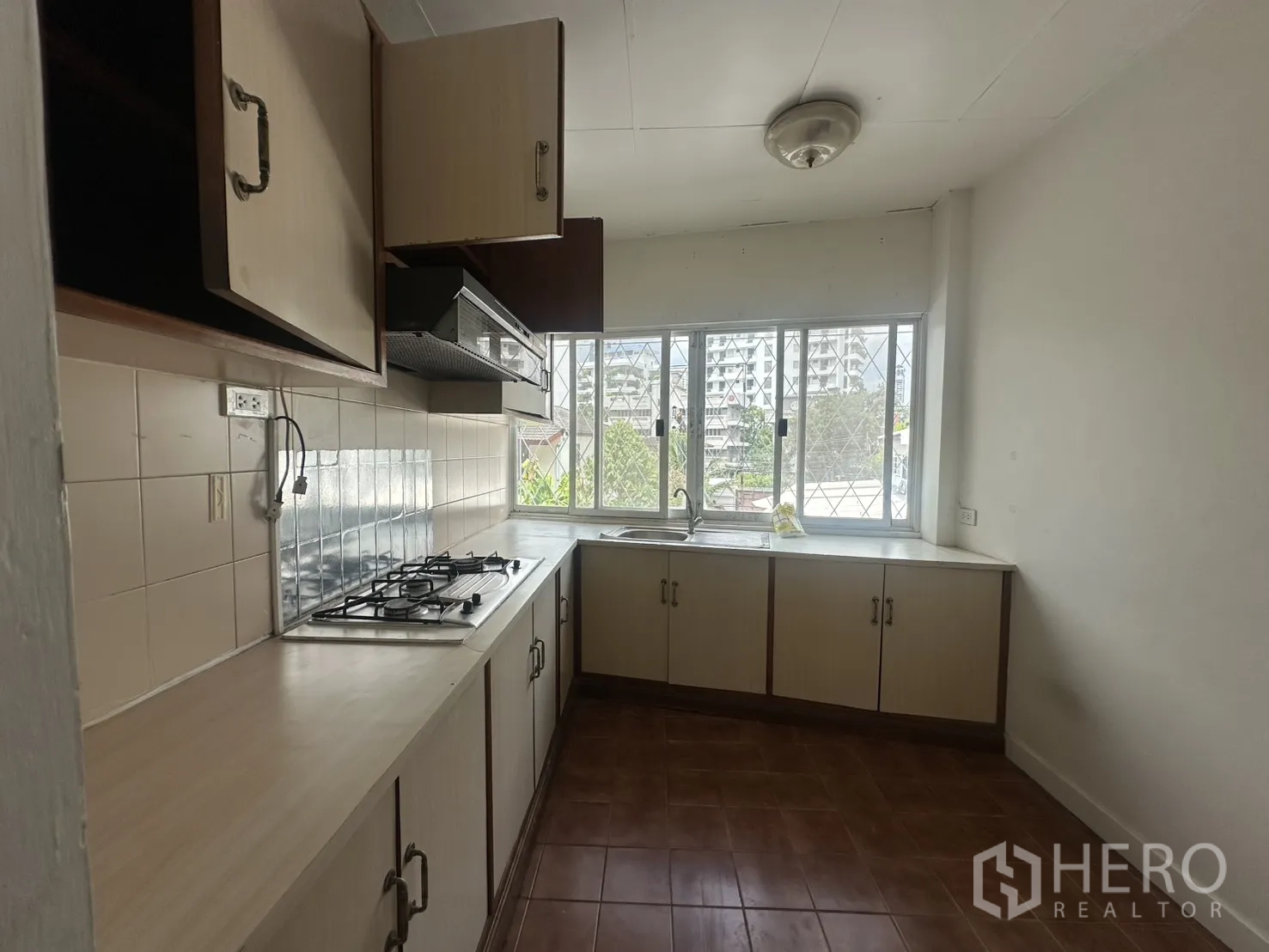 โฮมออฟฟิศ for rent in Watthana, Bangkok - ครัวแนวตรงพร้อมเตาแก๊ส ตู้เก็บของ และหน้าต่างบานใหญ่.