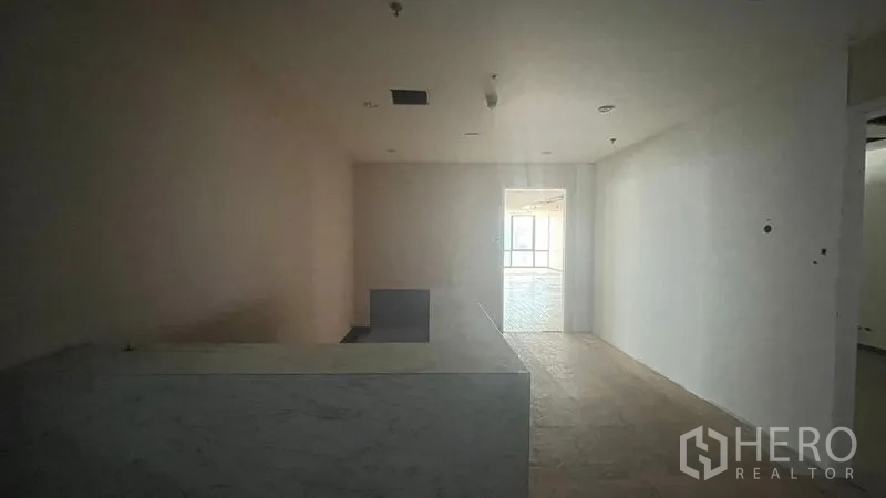Office Space for rent or sale - Reception area with stone counter and corridor leading to an open office space.