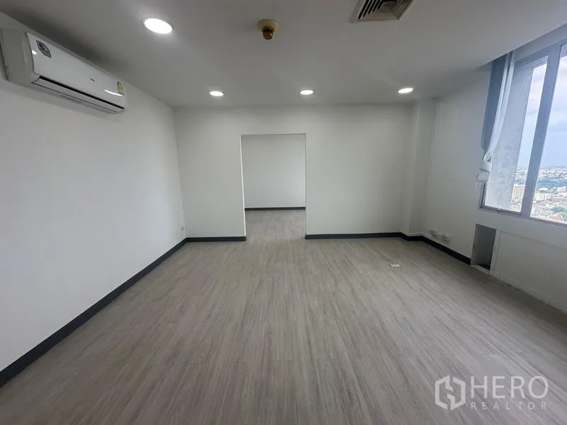 Office Space for rent - Bright office room with air conditioning, adjoining space, and skyline views through big windows.