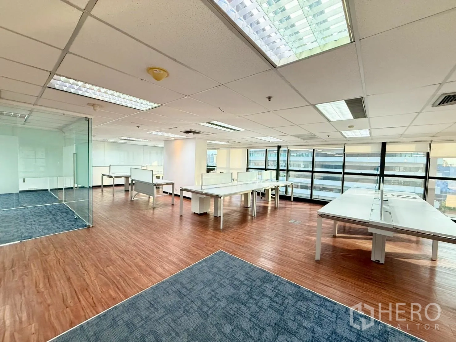 办公室 for rent in Watthana, Bangkok - 开放式办公室设大面积窗户、卷帘与白色长桌工位。