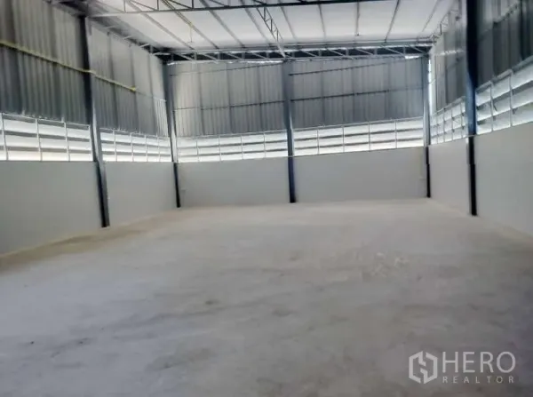 货栈 出租在Pathum Thani - 仓库内部空间开阔，层高高，钢结构梁架与平整混凝土地面。