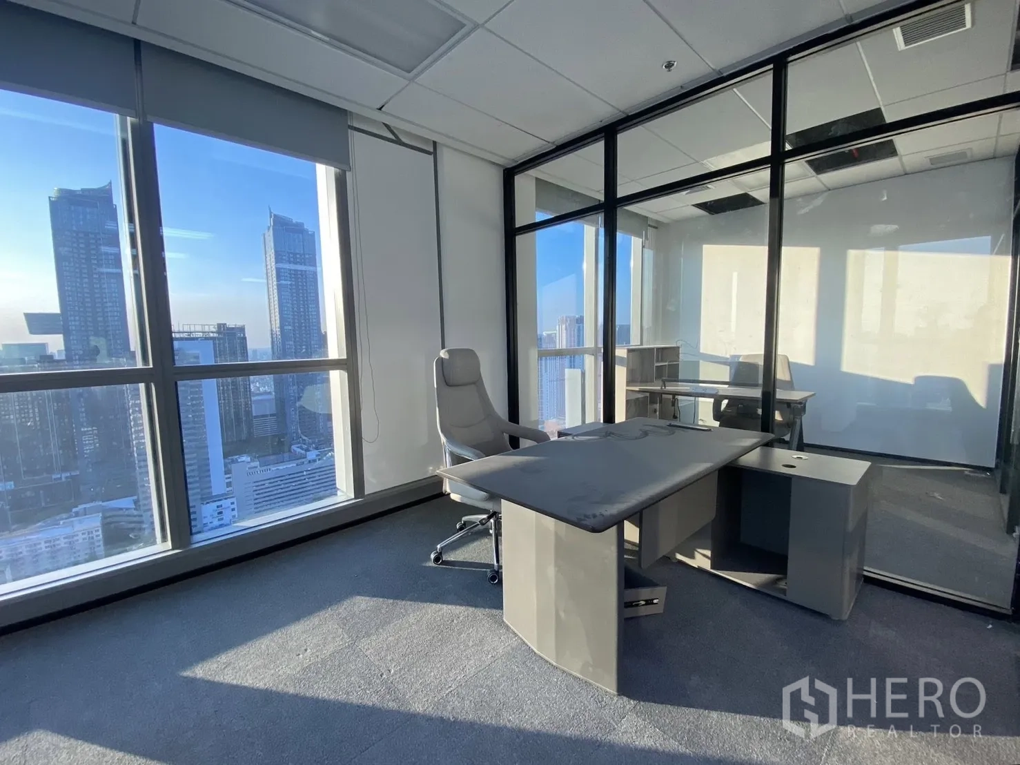 Office Space for rent in Huai Khwang, Bangkok - Corner executive office with floor-to-ceiling windows, city views and glass walls.