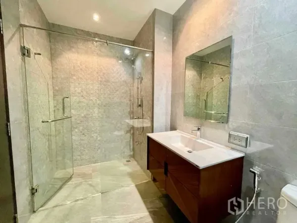 公寓 出租在Watthana, Bangkok - 现代浴室，宽敞玻璃淋浴间与单盆洗手台。