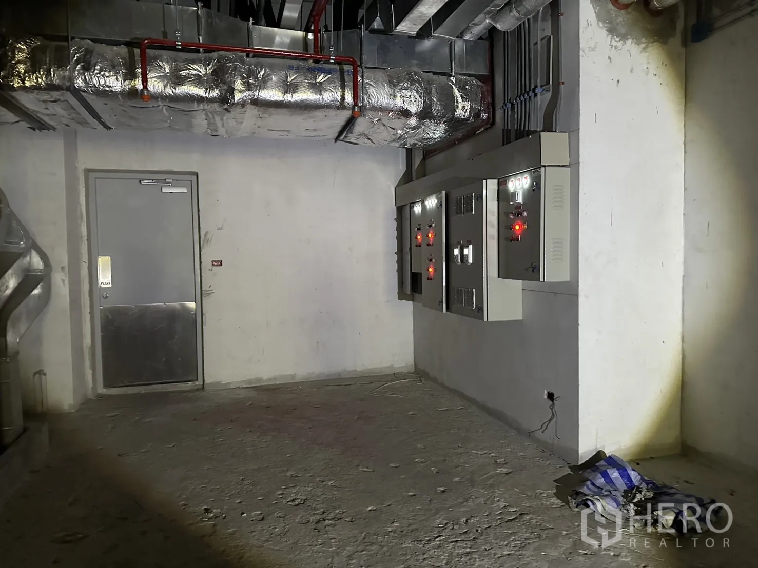 Retail Space for rent in Bang Rak, Bangkok - Back-of-house corner showing electrical control panels beside a metal door.