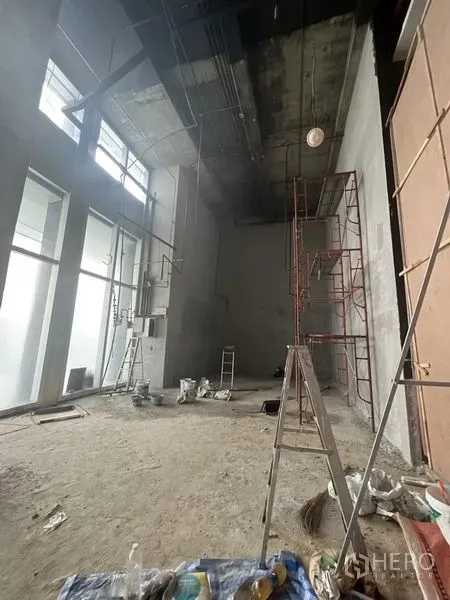 Retail Space for rent in Sathon, Bangkok - Spacious double-height retail interior with floor-to-ceiling windows and construction materials.