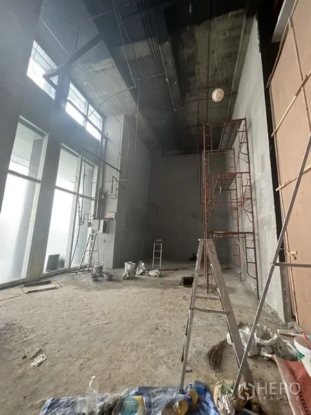 Retail Space for rent in Sathon, Bangkok - Spacious double-height retail interior with floor-to-ceiling windows and construction materials.