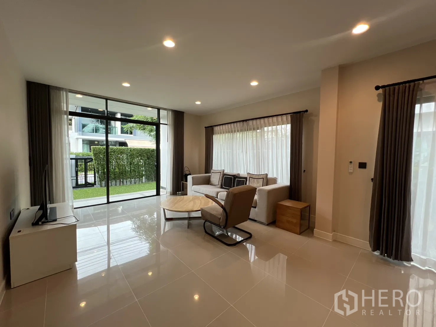 Detached House for rent in Bang Kapi, Bangkok - Living room with sliding glass doors opening to the garden.
