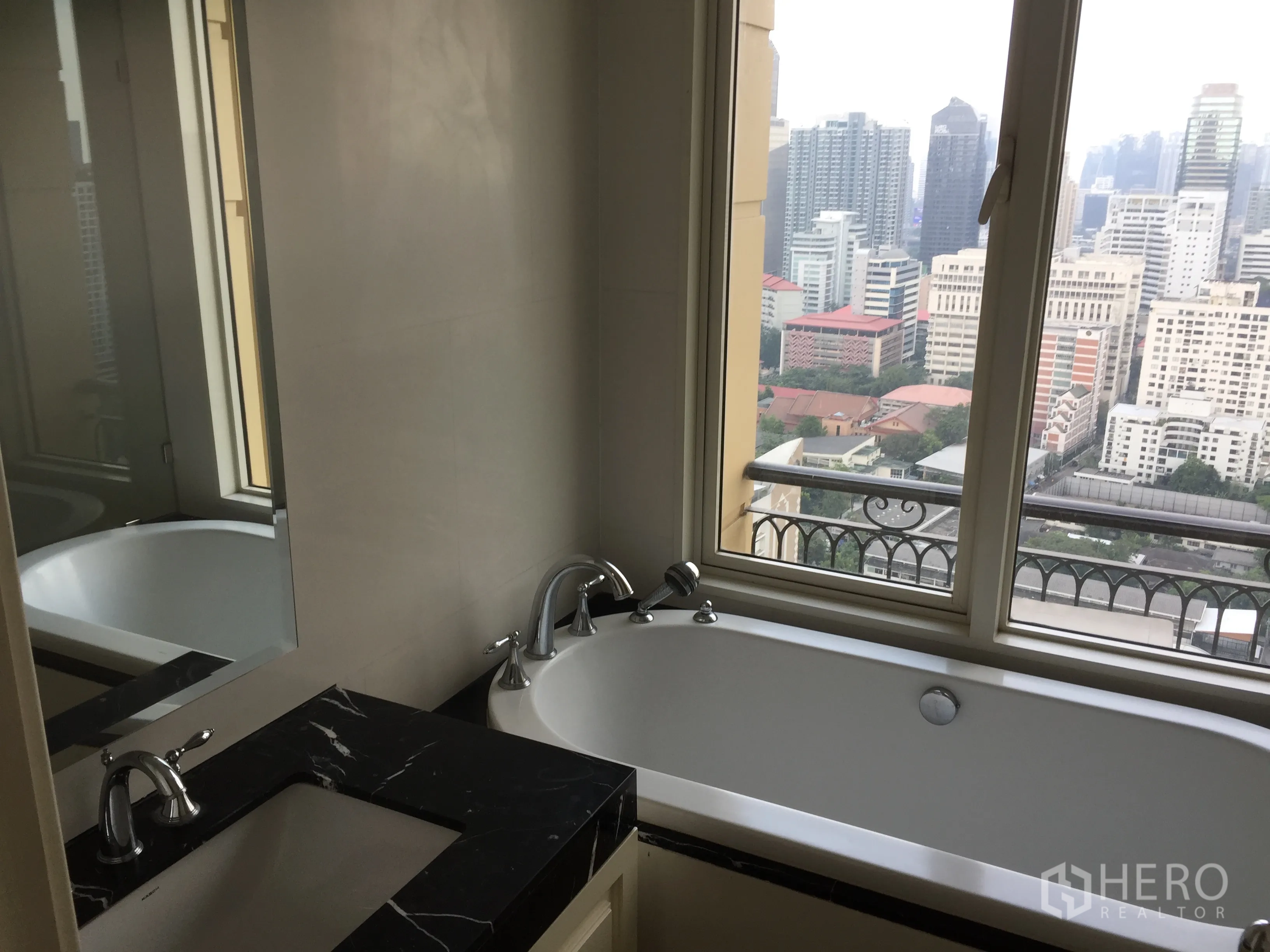 公寓 出租在Watthana, Bangkok - 浴室设黑石洗手台与窗边浴缸，可观曼谷天际线。