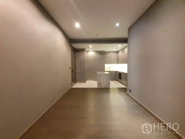 คอนโด ให้เช่าในHuai Khwang, Bangkok - ห้องนั่งเล่นยาว เชื่อมครัวโทนเทาพร้อมเกาะหินอ่อนและตู้เก็บของ