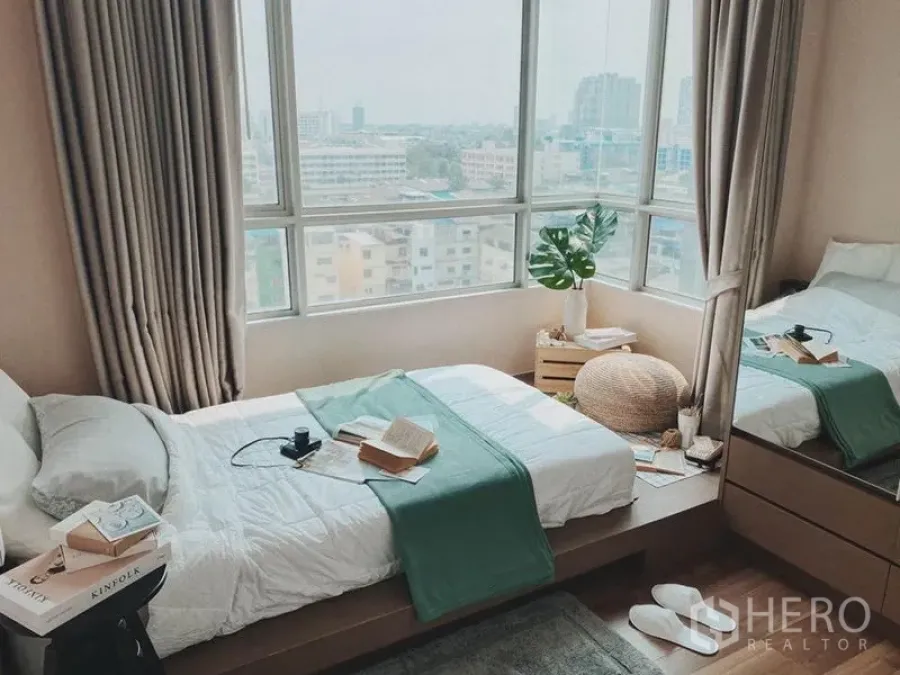 Condominium for rent in Thon Buri, Bangkok - Bright bedroom with corner windows and wide city views in a Thon Buri condo.
