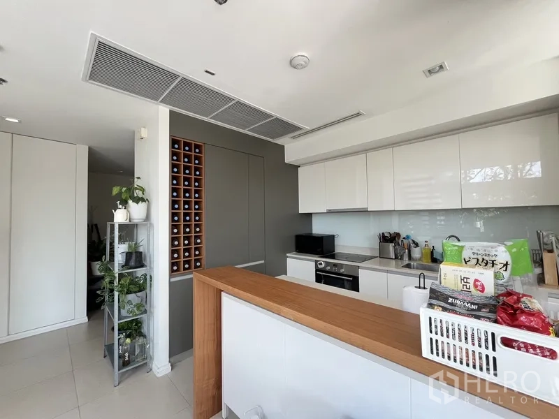 公寓 出售在Khlong San, Bangkok - 纯白厨房，岛台与木面台、内置酒格