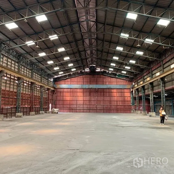 Warehouse for rent in Bang Kho Laem, Bangkok - Spacious warehouse interior with high steel‑truss roof, skylights and concrete floor.